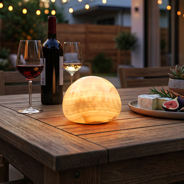 Starvox stone-look rechargeable table lamp glowing on an outdoor patio dining table